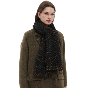 Chunky knit black scarf with multi-color speckles worn over an olive green wool coat