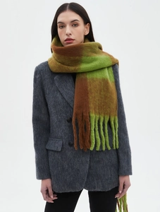 Detail of green and brown plaid scarf with thick long fringes on a grey wool blazer