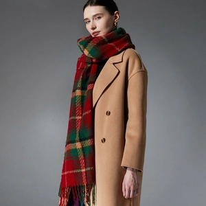 Classic red and green plaid fringe scarf paired with a beige double-breasted wool coat