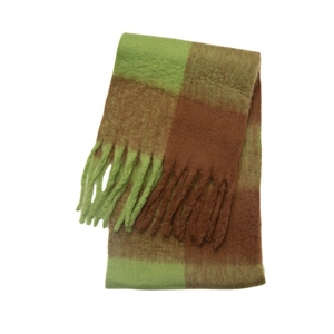 Detail of winter scarf featuring green and brown checkerboard pattern with chunky tassels