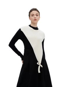 Detail showing ivory white chunky knit collar vest with a delicate bow tie accessory