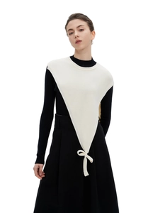 Close-up of white ribbed knit triangle shawl featuring a delicate bow tie on black top