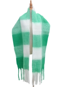 Detailed view of green and white plaid scarf with soft fringe and thick knit texture