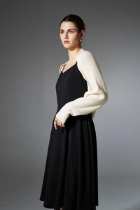 Close-up of off-white ribbed knit cropped cardigan shrug with soft texture and refined stitching