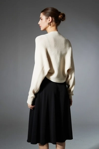 Detailed close-up of ribbed texture and elegant drape of a cream knit shawl