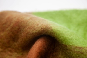 Macro shot of soft faux mohair fabric featuring bright green and caramel brown plaid texture
