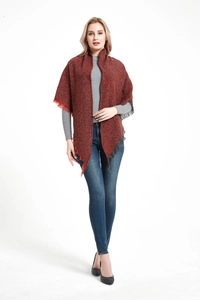 Close-up of reddish-brown knit shawl with fringe detail on a female fashion model