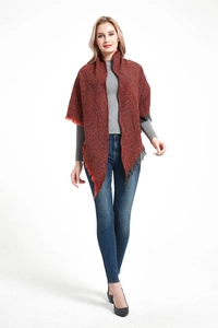 Front view of reddish brown knitted triangle shawl scarf with tassel trim on a model