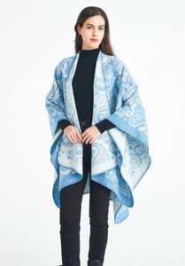 Detail of blue and white paisley wool shawl showing knit texture and drape on model