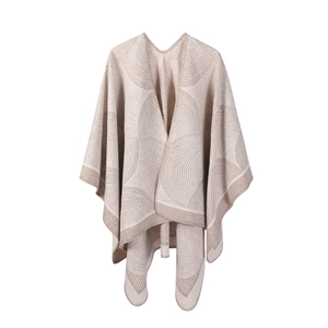 Détail d'un châle beige en laine avec motifs géométriques café et texture en maille douce