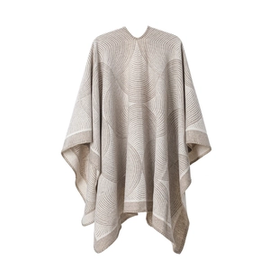 Détail macro de la texture à vagues géométriques sur ce poncho en laine beige