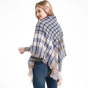 Close-up of gray and beige checkered shawl with fine fringe details on a model