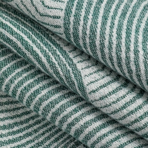 Détail macro du motif jacquard géométrique sur pashmina en mélange de laine vert et blanc