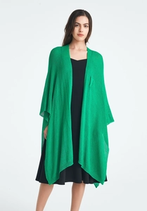 Detail of light green knit shawl showing the breathable fabric texture and relaxed fit
