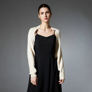 Women's cream white long sleeve knitted bolero shrug paired with a black slip dress