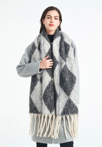Detailed view of the thick winter scarf featuring black argyle patterns and long cream tassels