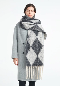 Detail of argyle pattern knit scarf with fringe edge on a grey wool coat
