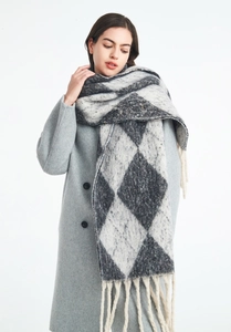 Detail showing checkered pattern and tassel fringe of the thick knit scarf