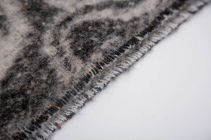 Macro detail of thick water ripple jacquard scarf showing grey textured boucle yarn fabric
