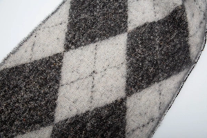 Macro shot of argyle knit scarf texture in grey and white wool blend with fringe detail