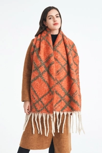 Dettaglio di sciarpa a quadri arancione in finto mohair con lunghe frange bianco crema