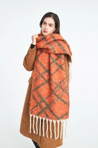 Dettaglio sciarpa a quadri arancione con spesse nappe color crema e trama effetto mohair