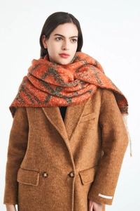 Dettaglio della sciarpa a quadri arancione e verde su cappotto in tweed marrone