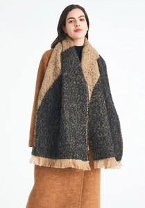 Detail of winter scarf showing thick camel and charcoal color block fabric with small tassels