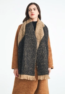 Close-up of thick winter scarf with brown color-blocking, fringe tassels and knit texture