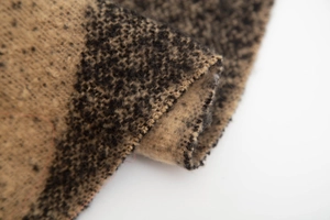 Detailed macro view of the thick jacquard knit scarf showing earthy bicolor fringe fibers