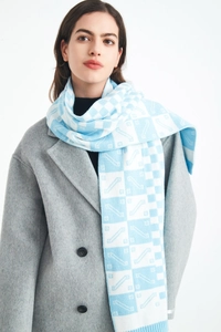 Detailed knit texture of light blue and white checkered scarf on a wool coat