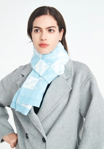 Close-up of a blue and white checkered knit scarf styled on a gray wool coat