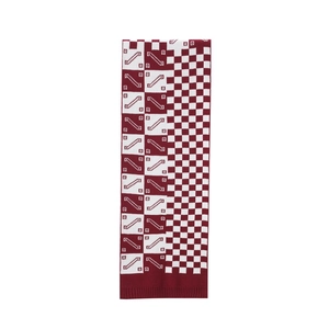 Detailed view of red and white checkerboard knit scarf with ribbed hem and soft texture