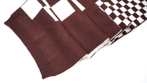 Detail of soft brown and white knitted scarf featuring checkered and block patterns