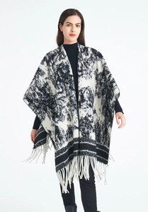 Detail view of monochrome ink wash pattern shawl with long white fringe accents