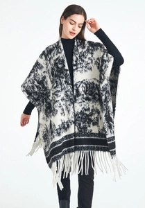 Detail shot of black and white jacquard knit shawl with long fringe hem decoration