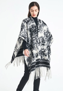 Detail of artistic black and white ink wash knit shawl with soft fringe trim accents