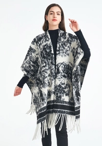 Detailed view of women's long knit shawl with black ink painting print and tassel hem
