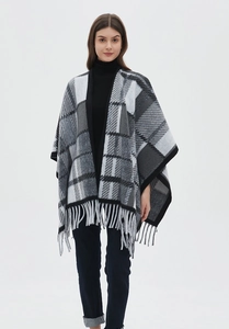 Detailed view of black and gray checkered shawl with fringe trim on a female model
