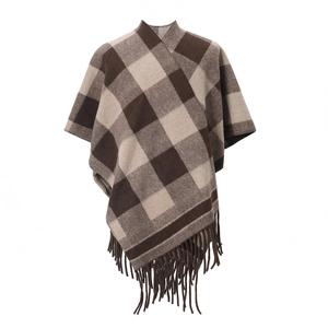 Detailed view of the thick fringe tassels on a brown checkered winter poncho wrap