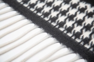 Close-up of classic black and white houndstooth shawl with elegant fringe detailing