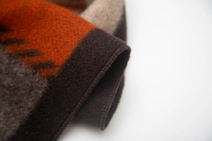Macro shot of thick wool texture and precise edge stitching on ink painting style shawl