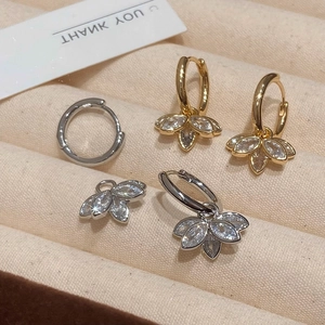 Élégantes boucles d'oreilles lotus en or et argent avec zircons dans un écrin à bijoux