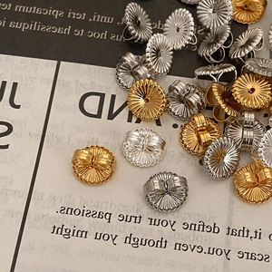 Golden and silver flower-shaped earring backs on vintage paper for DIY jewelry making