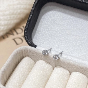 Close-up of luxury round zircon stud earrings in a white jewelry box with S925 silver finish