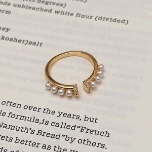 Vue macro détaillée d'une bague dorée vintage avec huit perles et accents de zircon