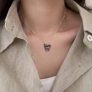 Collana minimalista in argento con ciondolo a gatto nero indossata da una modella