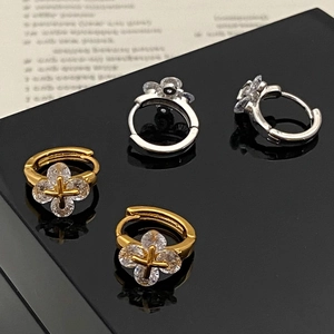 Vue détaillée des boucles d'oreilles trèfle en or et argent avec pierres zircons