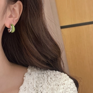 Eleganti orecchini a cerchio a C in argento e smalto verde indossati da una modella