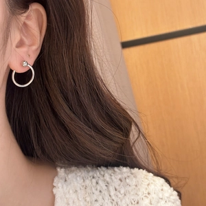 Minimalist silver C-shaped hoop earrings with bright zircon stone worn by a model